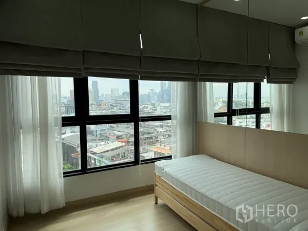 公寓 出租在Khlong Toei, Bangkok - 转角卧室，大窗与单人床，可见城市天际线。