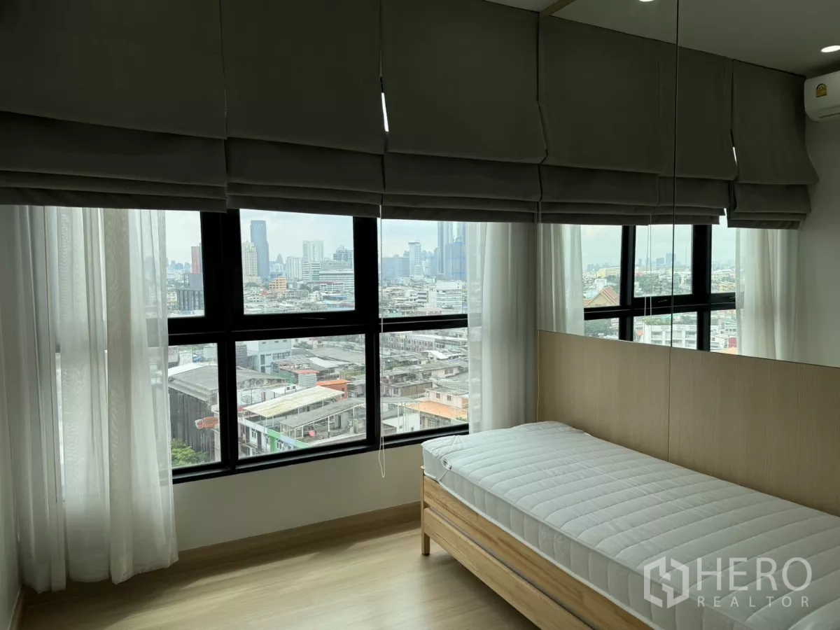 公寓 出租在Khlong Toei, Bangkok - 转角卧室，大窗与单人床，可见城市天际线。