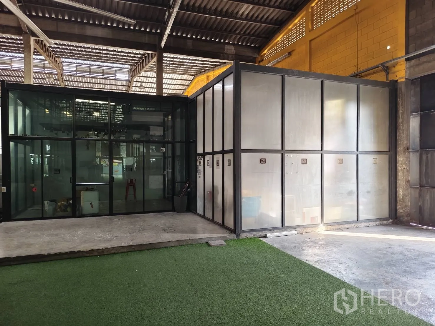 货栈 出租在Khlong Toei, Bangkok - 玻璃办公盒体，旁为人造草坪区与高屋顶。