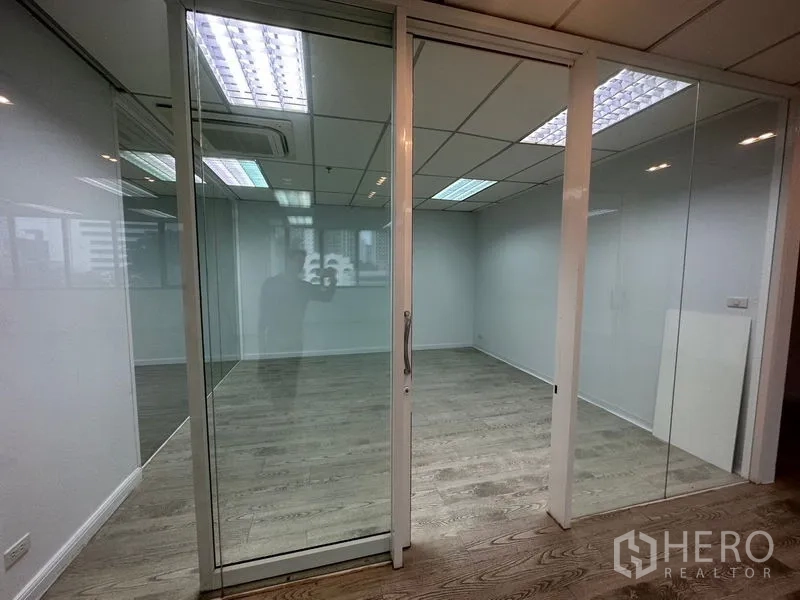 办公空间 出租在Din Daeng, Bangkok - 玻璃推拉门会议室，木纹地板与吊顶灯光。