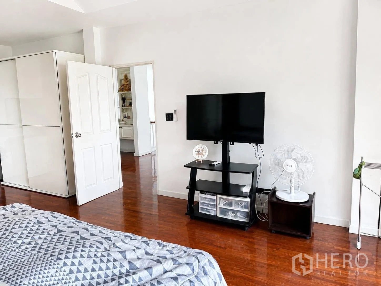 独栋房屋 for rent in Prawet, Bangkok - 卧室电视区，平板电视、衣柜与立式风扇，木地板。