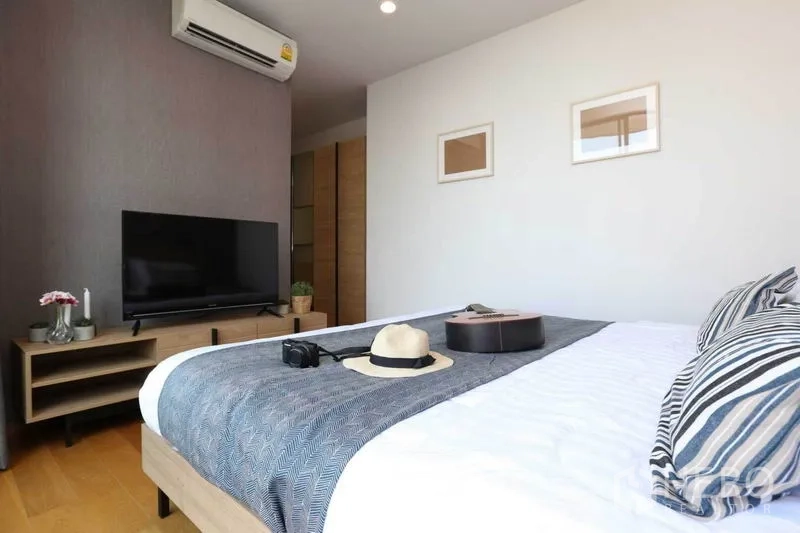 公寓 出租或出售在Bang Rak, Bangkok - 卧室视角，电视柜、空调与整洁铺设的床