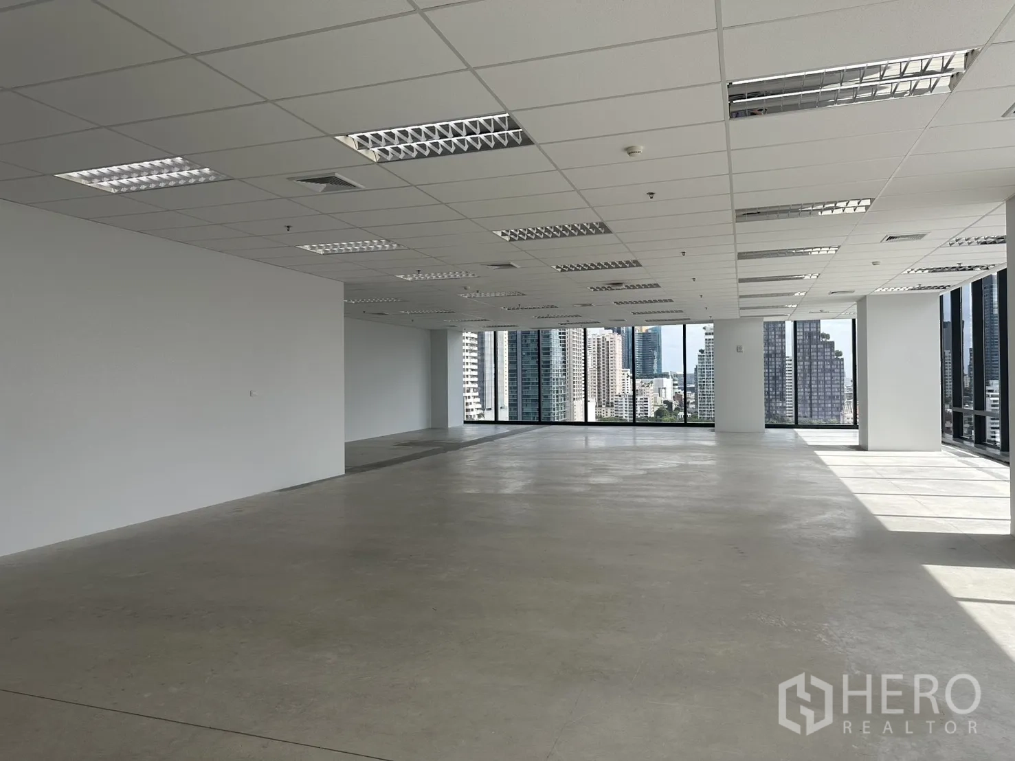 ออฟฟิศ for rent in Ratchathewi, Bangkok - พื้นที่มุมสว่างเพราะกระจกบานใหญ่ เพดานแบบกริดพร้อมไฟ และพื้นคอนกรีตขัดมัน