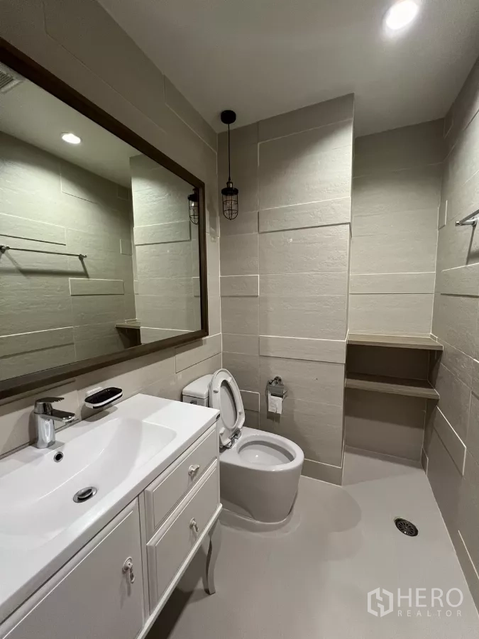公寓 出租在Bang Kapi, Bangkok - 客卫，白色洗手台、马桶与工业风吊灯。