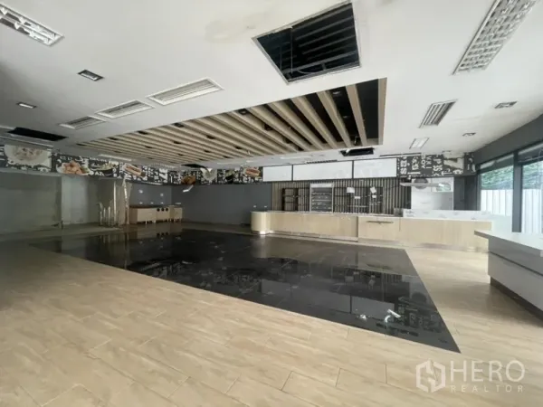 零售空间 出租在Khlong Toei, Bangkok - 宽敞展厅，设有长服务吧台、造型吊顶与亮黑色地面区。