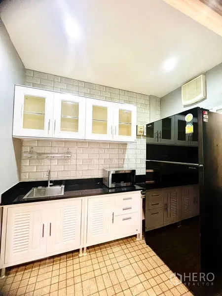 联排别墅 出租在Prawet, Bangkok - 小型备餐区，白色橱柜、地铁砖背景墙与黑色台面
