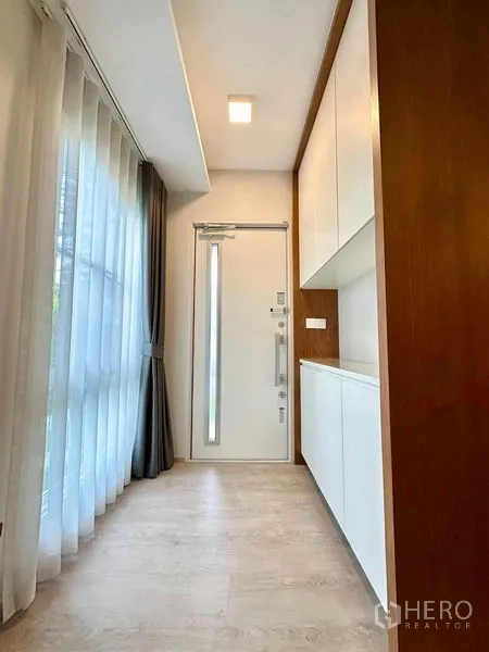 独立式住宅 出租或出售在Prawet, Bangkok - 入户走廊，高挑入户门与落地窗，内置储物柜。