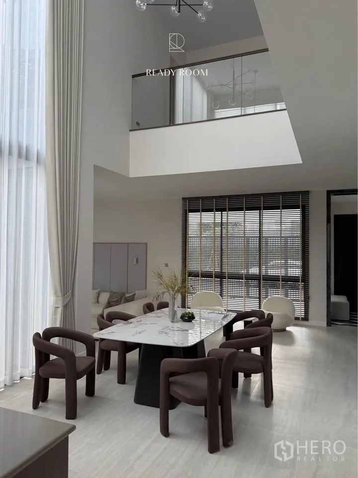 Detached House for rent in Bang Kapi, Bangkok - Double‑height space with dining table set beneath expansive windows.