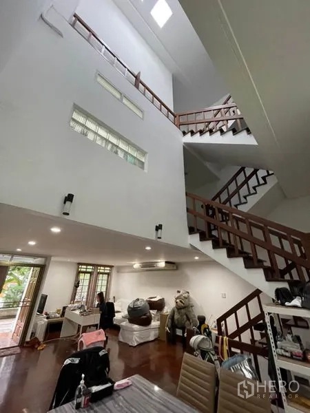 联排别墅 出租在Khlong Toei, Bangkok - 挑高客厅带天窗与木质楼梯，开放式布局。