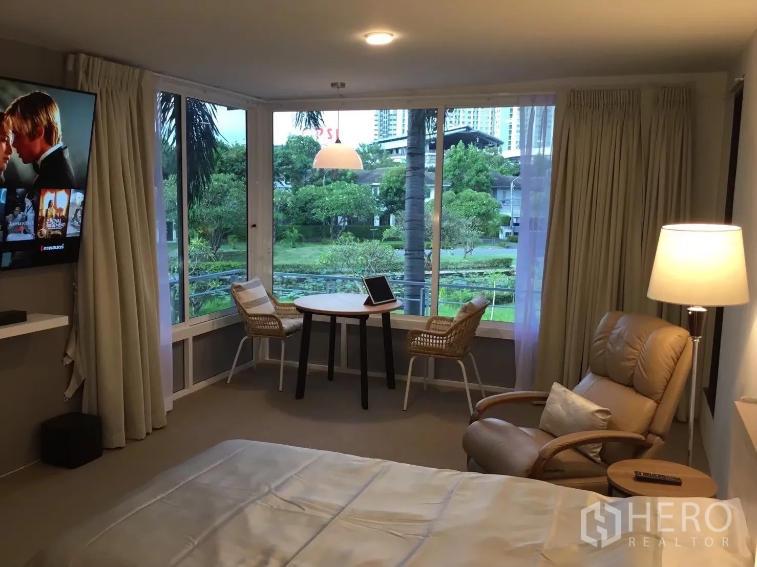 独栋房屋 for sale in Suan Luang, Bangkok - 卧室配躺椅与小桌，旁有大窗。