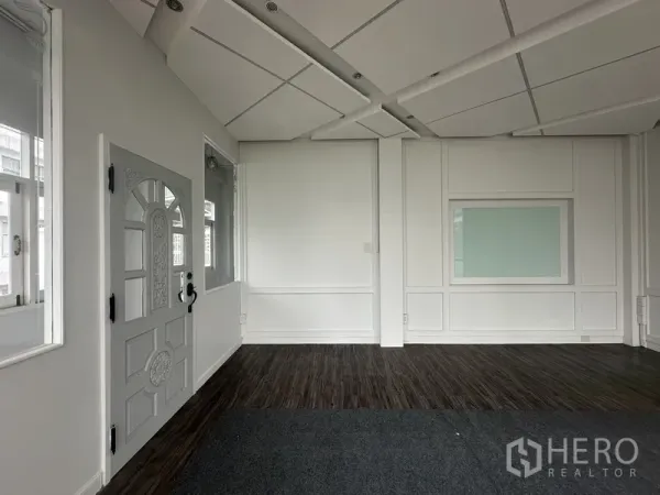 Retail Space for rent in Bang Rak, Bangkok - Bright interior with paneled walls, acoustic ceiling, and a windowed door.