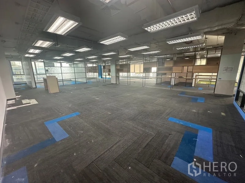 办公空间 出租在Bang Rak, Bangkok - 铺地毯的开放工作区，栅格灯与玻璃隔断。
