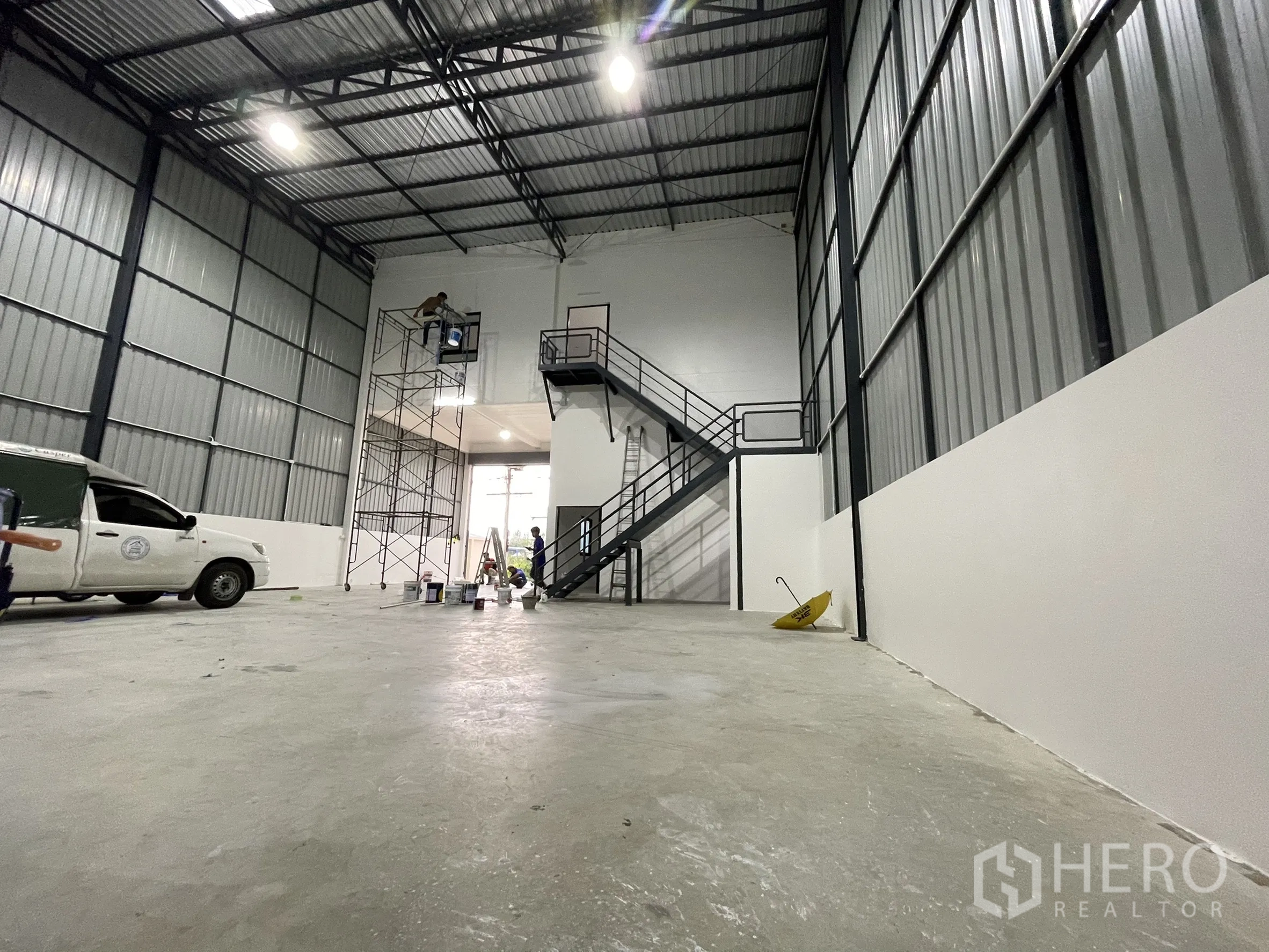 Factory for rent or sale in Lam Luk Ka, Pathum Thani - Tall warehouse hall with metal walls, steel staircase to mezzanine, and open loading area.