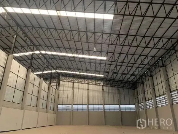 Warehouse for rent in Bang Pa-in, Phra Nakhon Si Ayutthaya - Spacious warehouse interior featuring a high clear-height steel truss roof and natural light panels.
