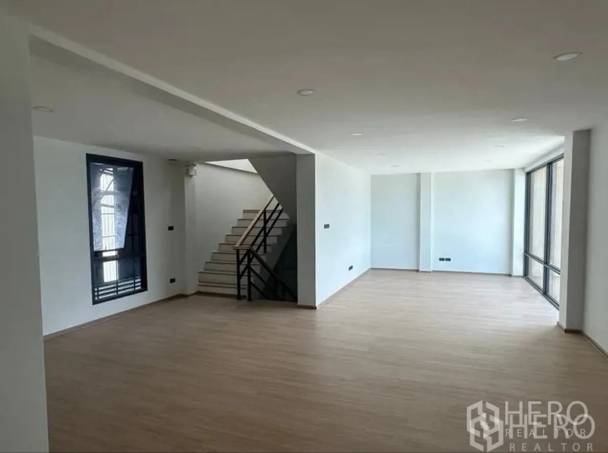 仓库 for sale in Lam Luk Ka, Pathum Thani - 开放式办公楼层，带楼梯、筒灯和落地玻璃窗。