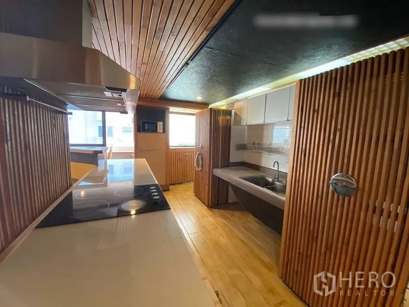 Condominium for rent or sale in Suan Luang, Bangkok - Bright kitchen zone with electric hob, sink, wood partitions and large windows.