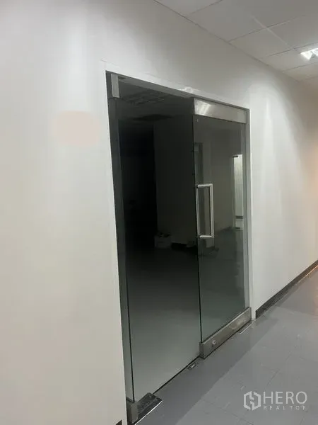 办公空间 出租 - 白色走廊中的玻璃门办公室入口，灰色地砖。