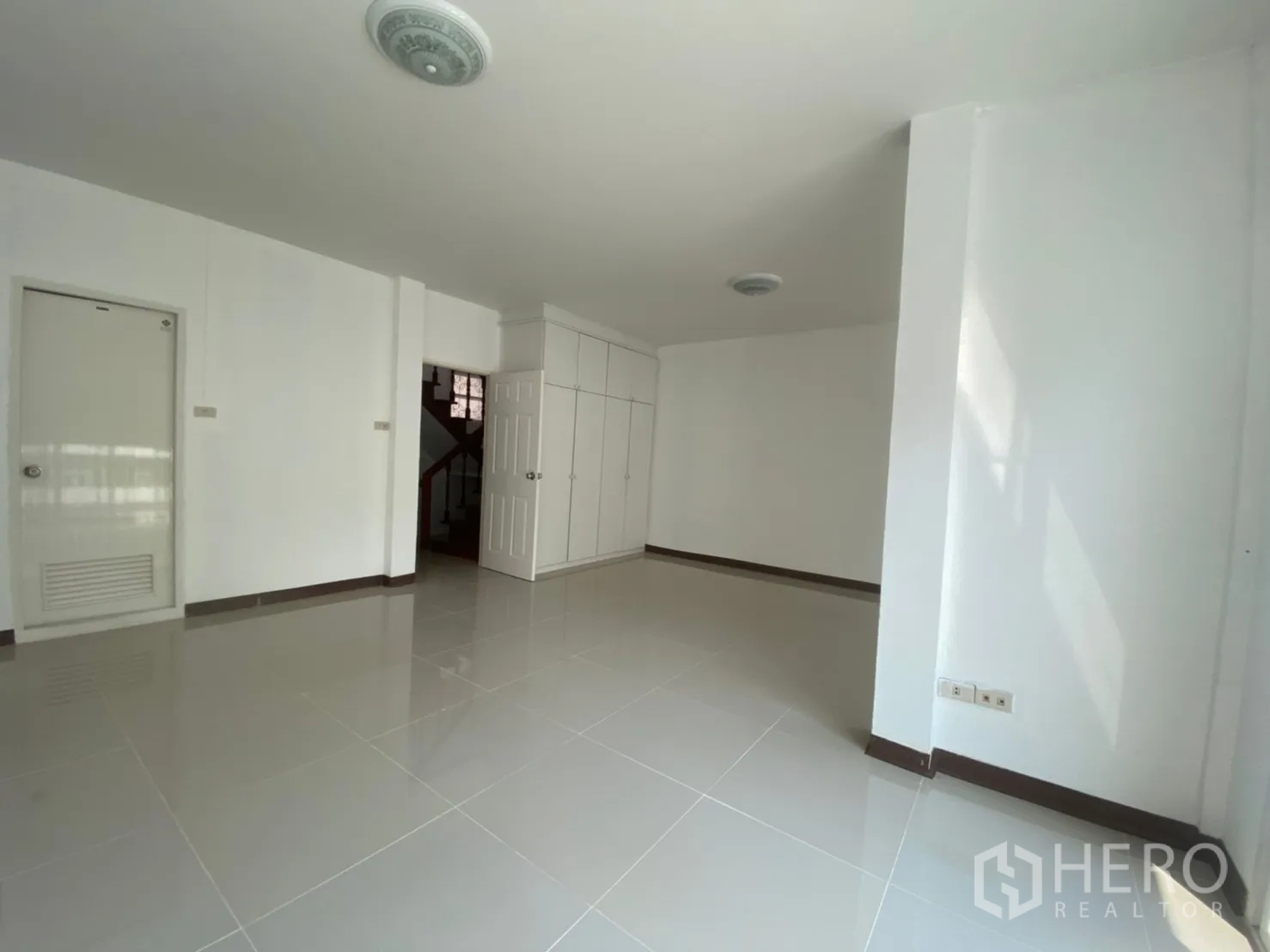 Townhouse for rent in Watthana, Bangkok - Large multipurpose room with built-in cabinets and access to the staircase.