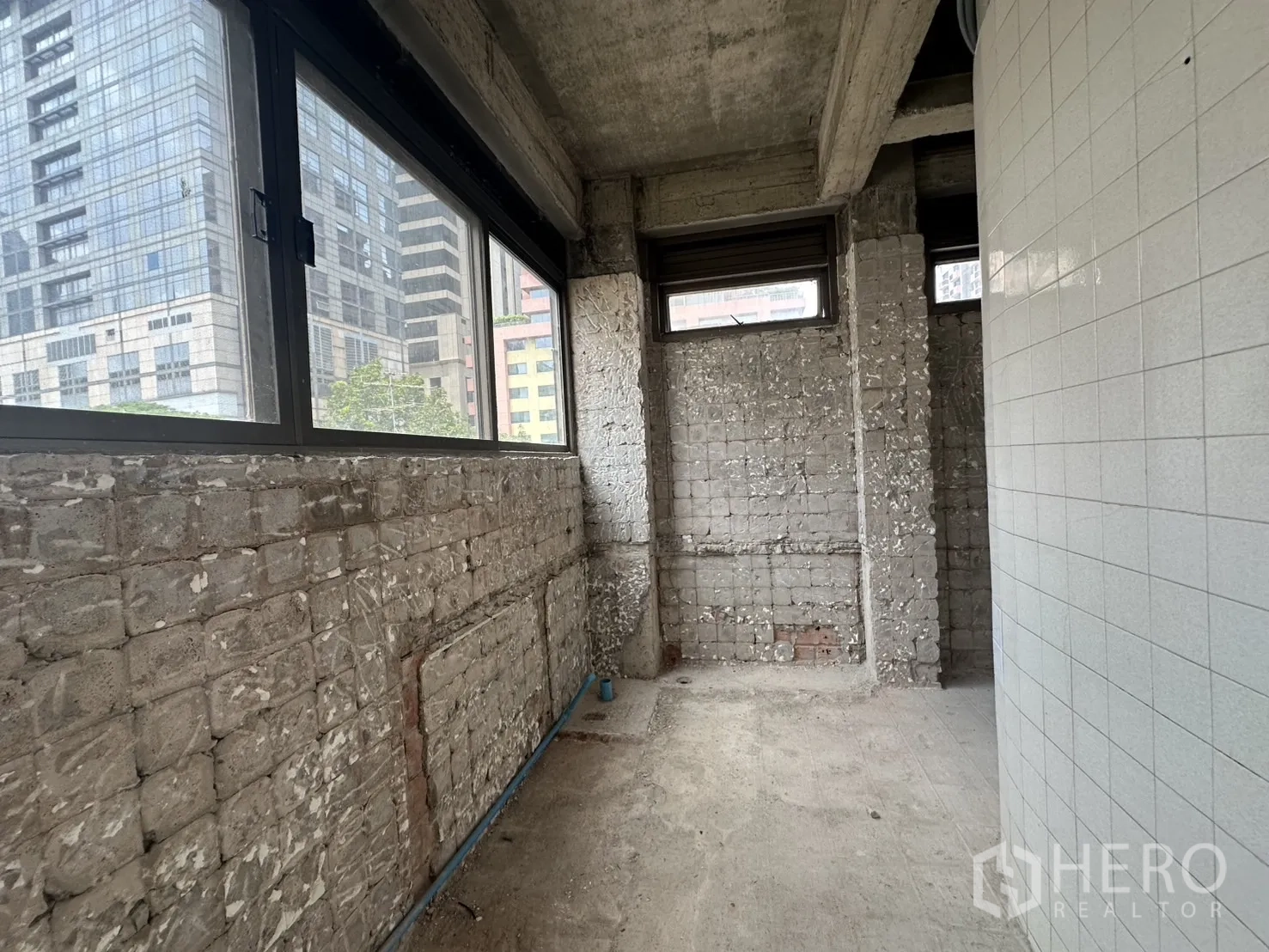零售空间 出租在Bang Rak, Bangkok - 服务走廊，裸砖墙与窗户，可眺望城市办公楼。