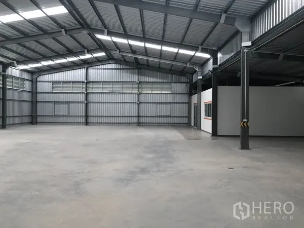 Warehouse for rent in Mueang Nonthaburi, Nonthaburi - Spacious open-plan warehouse interior with steel beams, skylights and smooth concrete flooring.