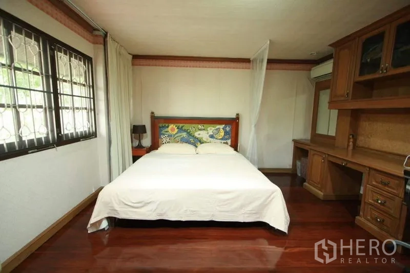 独立式住宅 出租在Bang Phli, Samut Prakan - 卧室设防盗窗格、长书桌与衣柜，木地板。