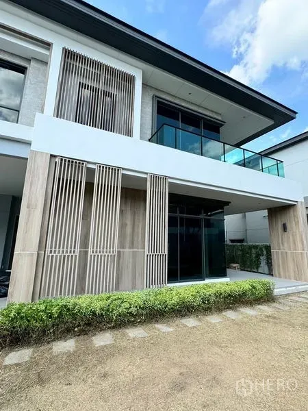 บ้าน ให้เช่าหรือขาย - มุมมองด้านหน้าบ้านสมัยใหม่อีกครั้ง พร้อมระเบียงกระจกและซี่ระแนงข้างสนามหญ้า
