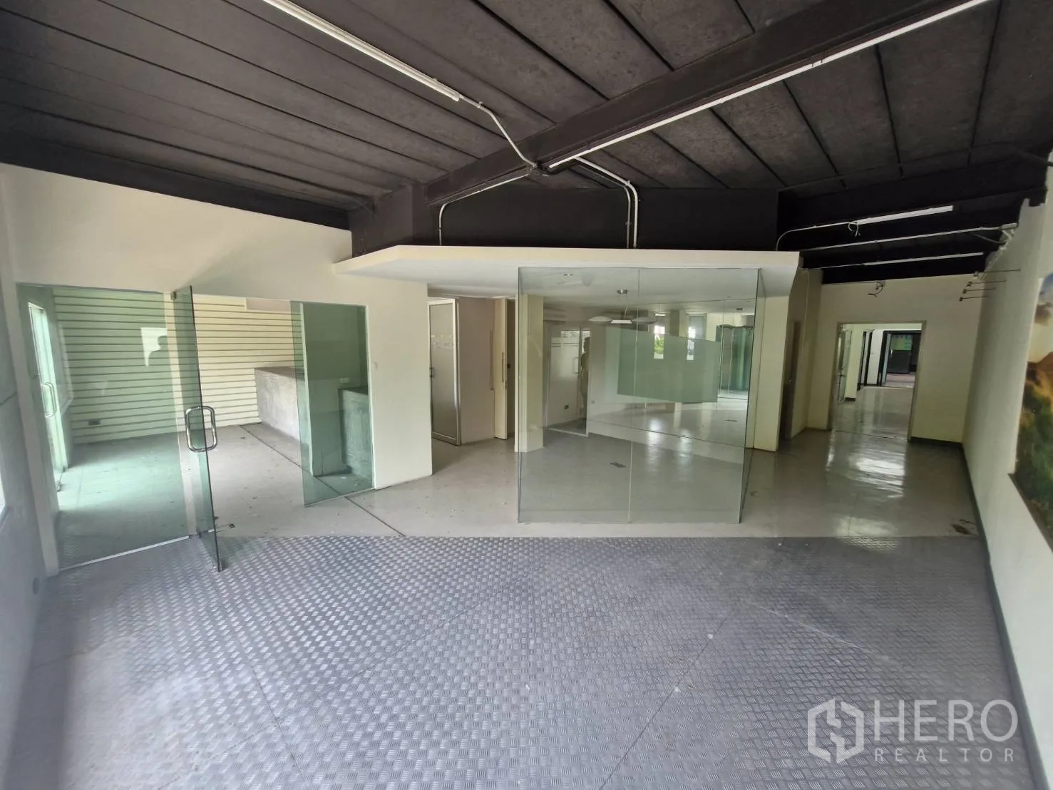 Warehouse for rent in Suan Luang, Bangkok - Wide lobby with glass partitions, dark ceiling and checker-plate flooring.