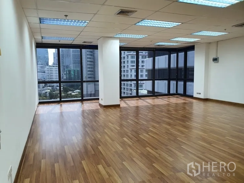 办公空间 出租在Watthana, Bangkok - 转角办公室，落地窗全景可见素坤逸高楼与绿景。