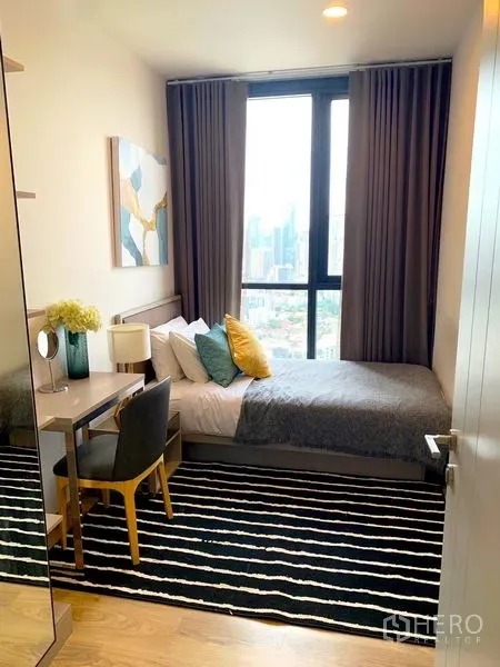 公寓 出租在Khlong Toei, Bangkok - 紧凑卧室，条纹地毯与书桌，大窗观景。