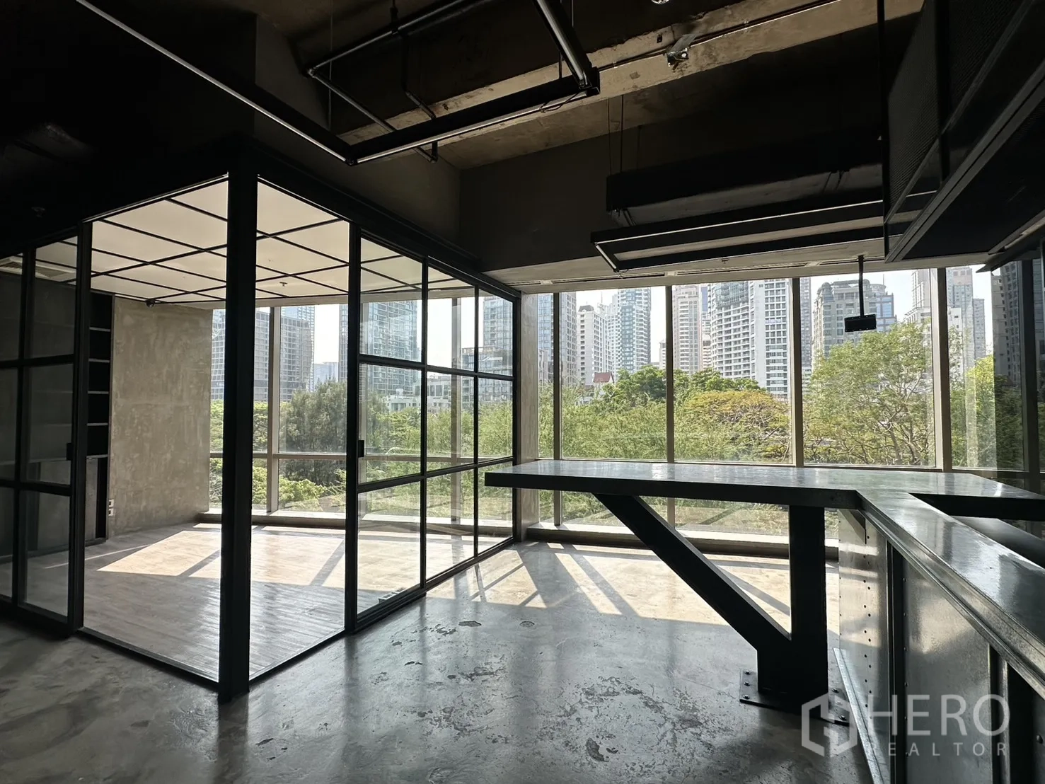 Office Space for rent in Pathum Wan, Bangkok - Industrial-style office with floor-to-ceiling windows, glass meeting room, and green park and skyline views.