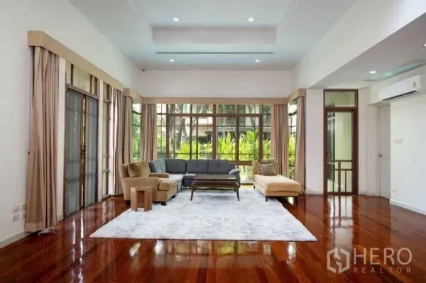 บ้าน ให้เช่าหรือขายในWatthana, Bangkok - ห้องนั่งเล่นโปร่งสว่าง กระจกเต็มบาน โซฟามุม มองเห็นสวน พื้นไม้ขัดเงา