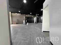 Retail Space for rent in Khlong Toei, Bangkok - Large flexible showroom area with dark ceiling, track lighting and sleek herringbone floor.
