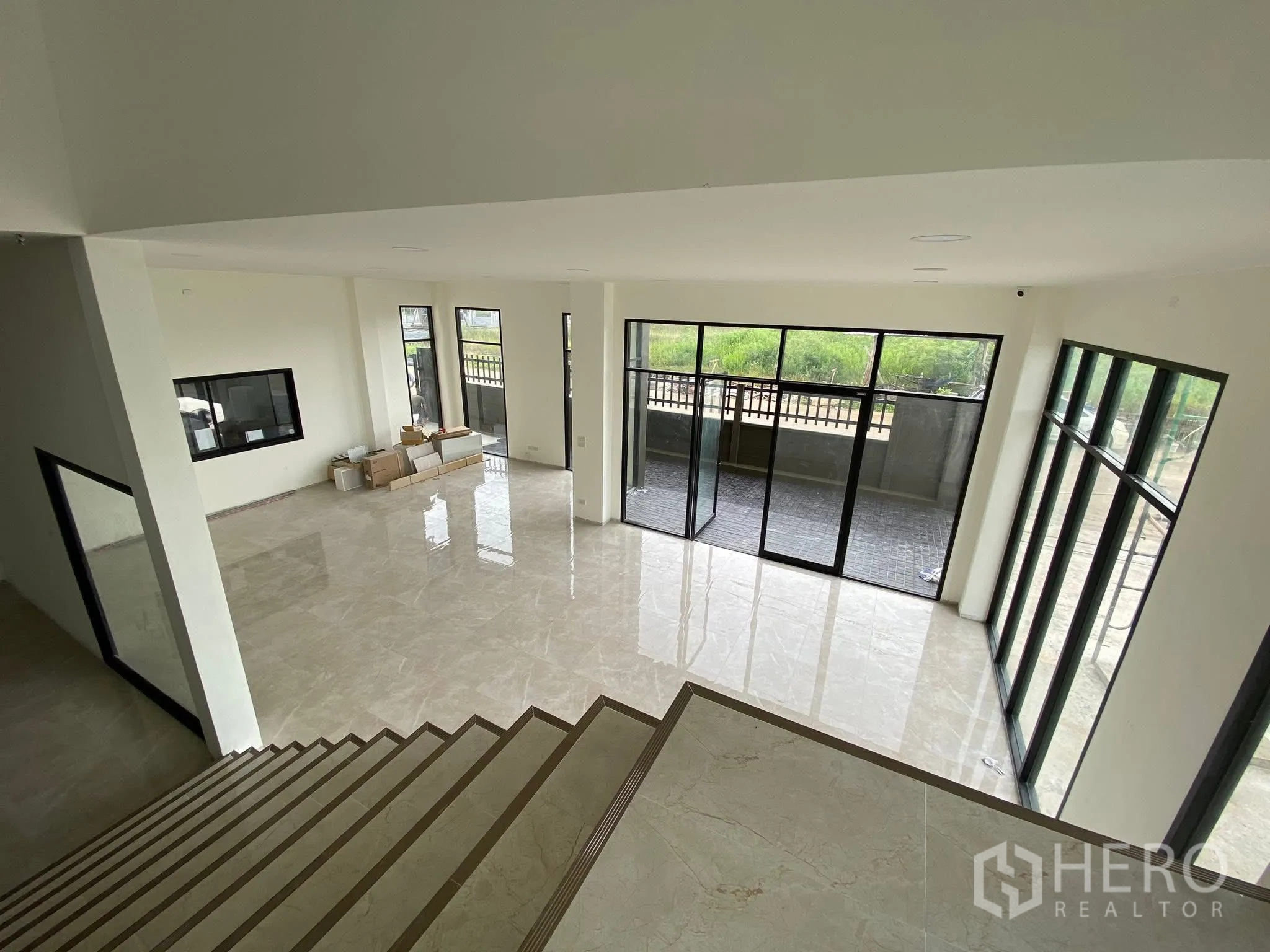 โรงงาน for rent in Krathum Baen, Samut Sakhon - มุมมองจากบันไดลงสู่โถงออฟฟิศเพดานสูง ผนังกระจกเต็มบาน