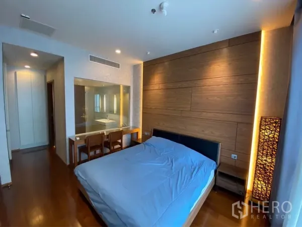 คอนโด ให้เช่าหรือขายในWatthana, Bangkok - ห้องนอนผนังลายไม้ โต๊ะทำงาน/โต๊ะเครื่องแป้ง และช่องกระจกมองเข้าไปยังห้องน้ำในตัว