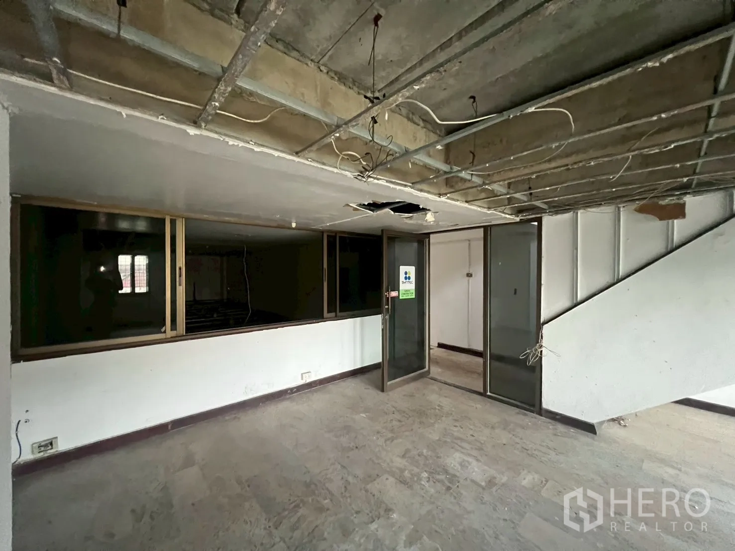 Shophouse for rent in Phra Khanong, Bangkok - Open workspace featuring sliding glass panels and unfinished ceiling.