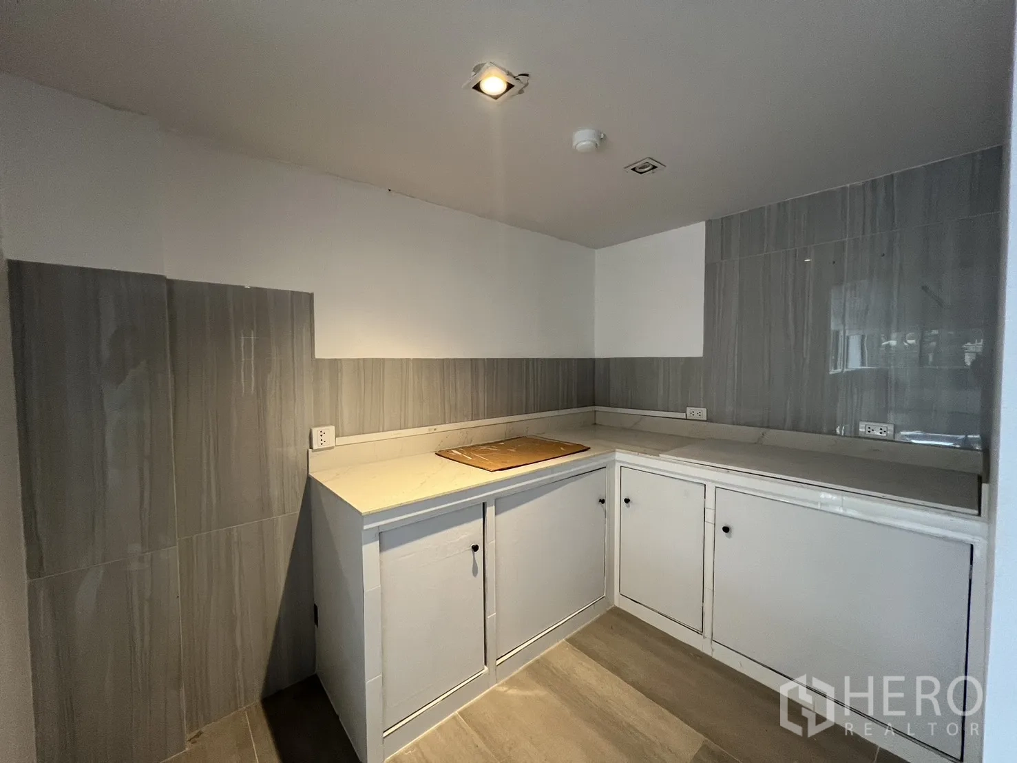 Retail Space for rent in Khlong Toei, Bangkok - Entrance to restroom with patterned floor beside built-in shelving.