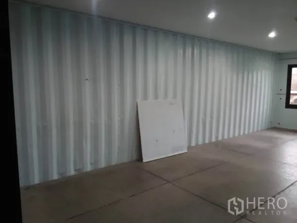 Retail Space for rent in Khlong Toei, Bangkok - Empty 30 sqm retail unit with corrugated metal wall, LED downlights and concrete floor.