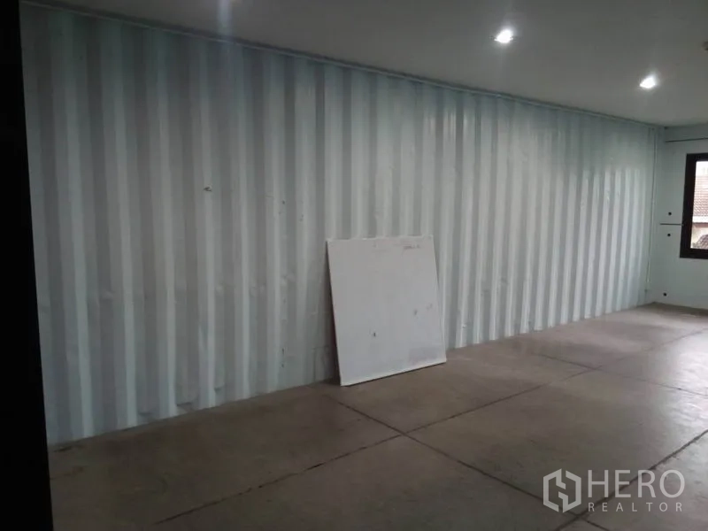 Retail Space for rent in Khlong Toei, Bangkok - Empty 30 sqm retail unit with corrugated metal wall, LED downlights and concrete floor.