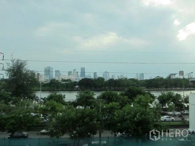 Condominium for rent in Khlong Toei, Bangkok - City skyline view across a large lake and treetops from the balcony.
