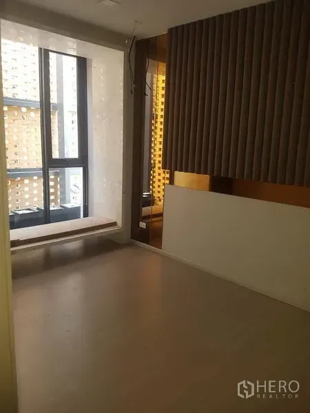 Retail Space for rent in Khlong Toei, Bangkok - Compact interior room with floor-to-ceiling window, built-in bench, and acoustic wall panels.