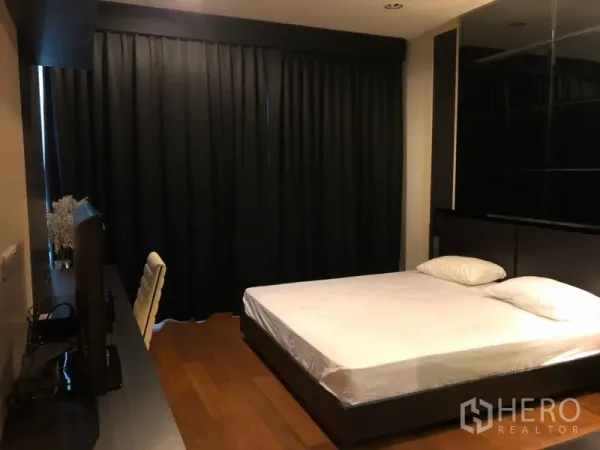 公寓 出租在Pathum Wan, Bangkok - 次卧配大床、遮光窗帘与电视柜，木地板。