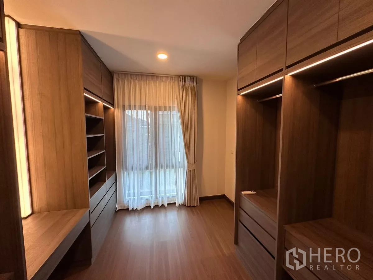 独立式住宅 出租在Bang Phli, Samut Prakan - 步入式衣帽间，木质柜体、搁架与梳妆台。