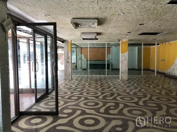 Retail Space for rent in Khlong Toei, Bangkok - Spacious showroom area with glass partitions and exposed columns.