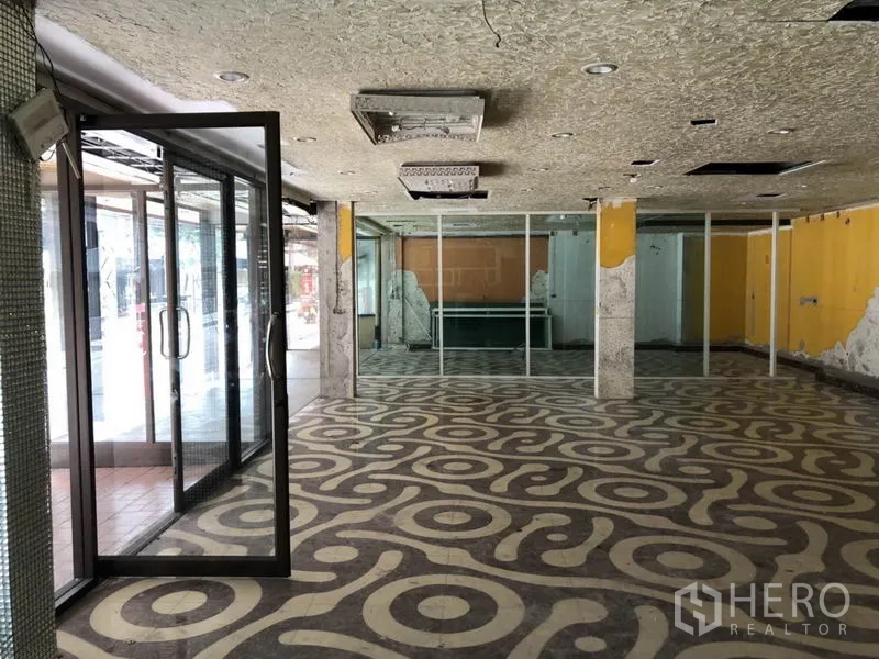 Retail Space for rent in Khlong Toei, Bangkok - Spacious showroom area with glass partitions and exposed columns.