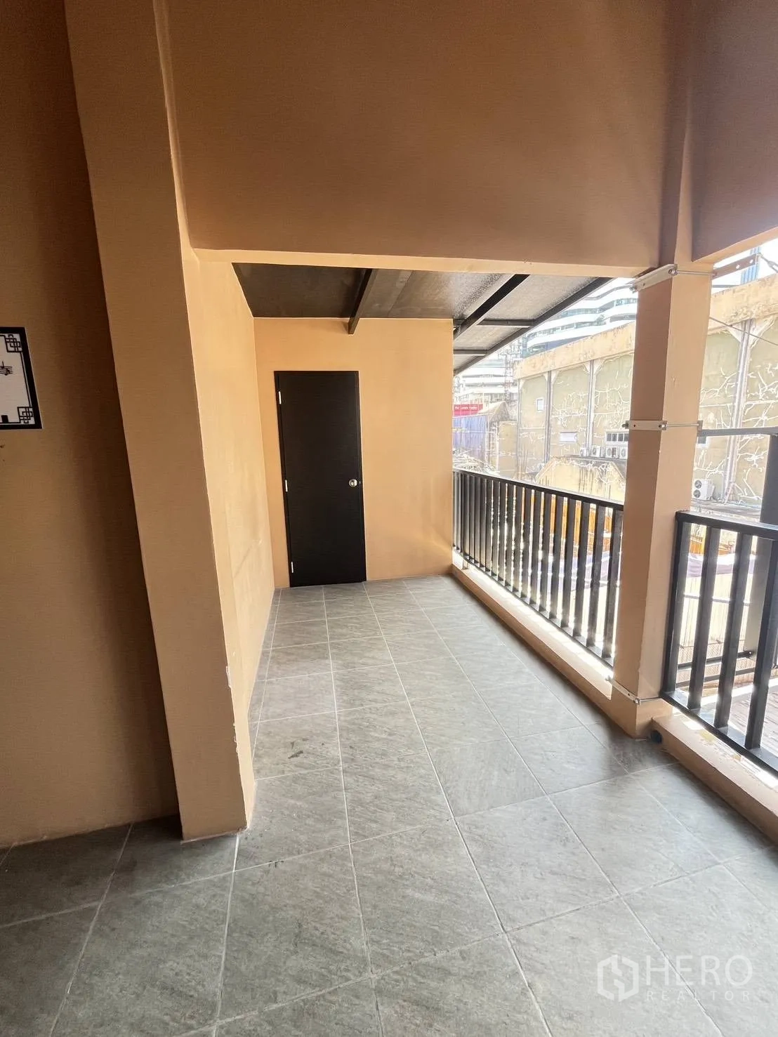 零售空间 for rent in Watthana, Bangkok - 带金属栏杆的长形有顶阳台走道与黑色门。