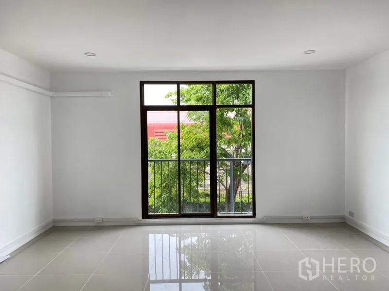 带办公室的家 出租在Wang Thonglang, Bangkok - 明亮房间，落地窗与小阳台栏杆，面向绿树。
