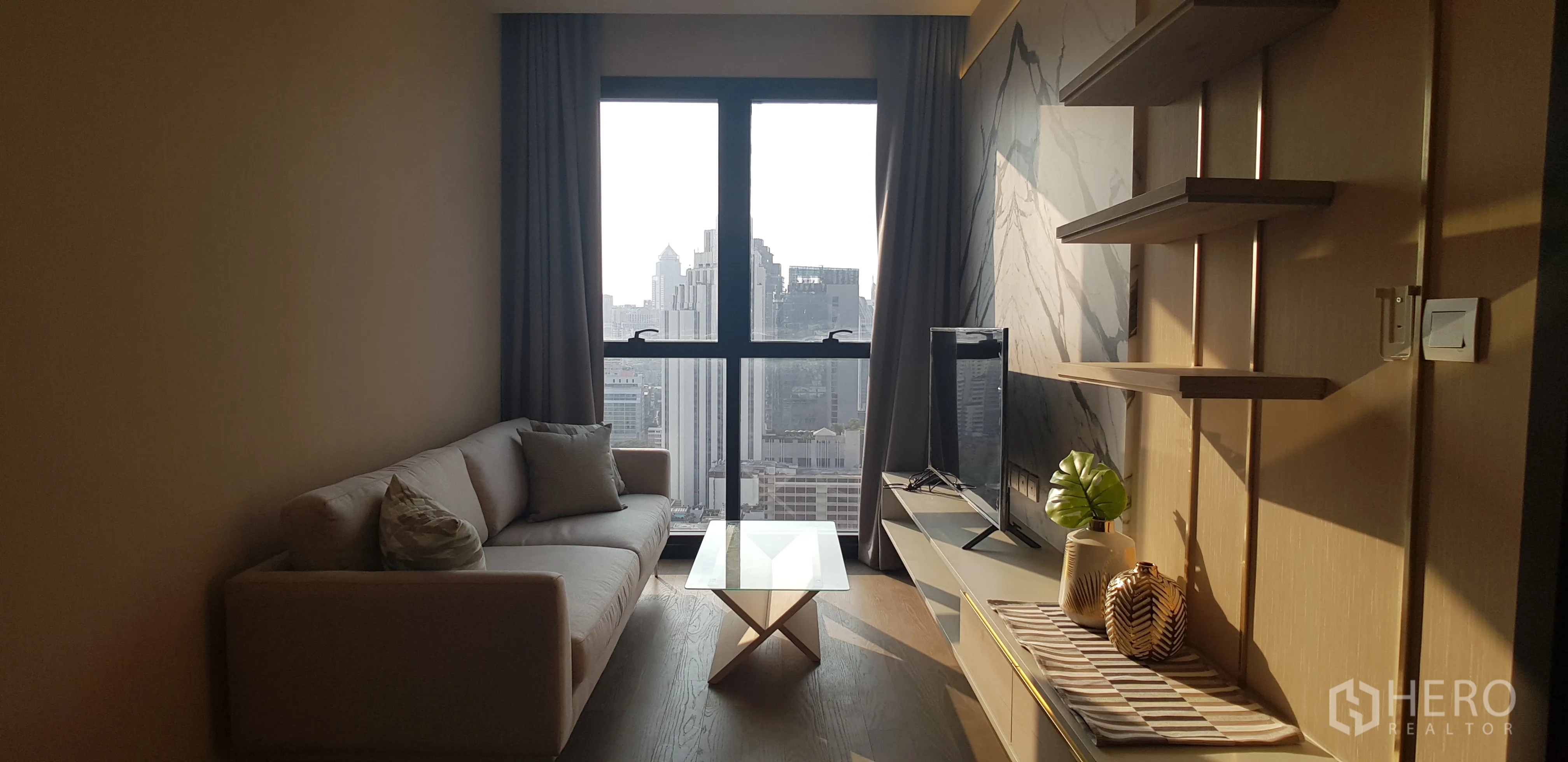 คอนโด for rent in Watthana, Bangkok - โซฟาและทีวีข้างผนังลายหินอ่อน พร้อมหน้าต่างบานใหญ่ชมวิวเมือง