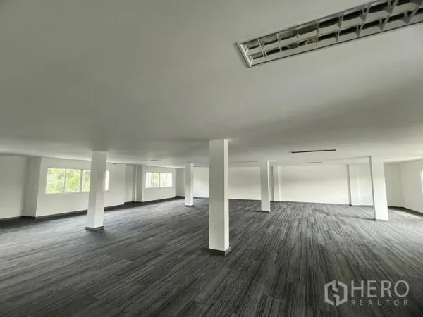 Retail Space for rent in Huai Khwang, Bangkok - Bright open retail interior featuring multiple pillars, grey carpet tiles, and fluorescent light panels across a wide flexible space.