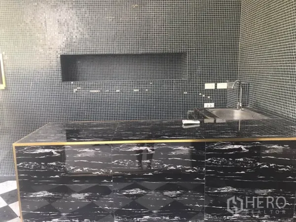 Retail Space for rent in Watthana, Bangkok - Built-in black stone counter with sink and mosaic tile walls inside the shop.