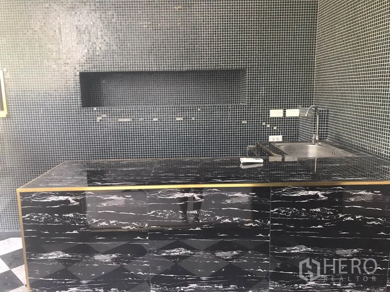 Retail Space for rent in Watthana, Bangkok - Built-in black stone counter with sink and mosaic tile walls inside the shop.